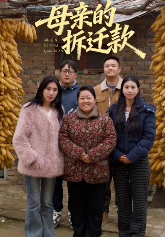 院落与悬挂玉米前站着五名人物，上方保留《母亲的拆迁款》片名。